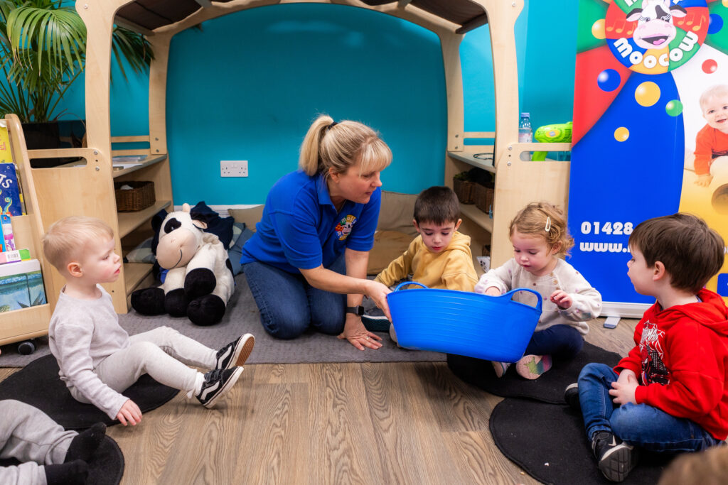 Children taking toys from a container in a Molly Moocow class
